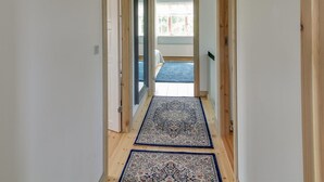 A hallway with wooden flooring, a blue patterned rug, and a door leading to a room with a bed and a window. - "Lioba" - 400m from the sea by Interhome (Vejers Strand)