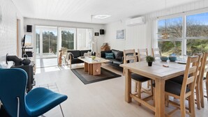 Un vaste espace de vie comprenant une table à manger, des chaises, un canapé et un téléviseur.