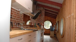 Una cucina con mobili in legno, parete in mattoni e finestra.