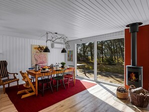 A modern interior with a dining area, a fireplace, and a view of the outdoors.