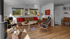 Una sala de estar moderna con chimenea, piso de madera y un rincón de estar acogedor.