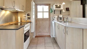 Une cuisine de taille réduite équipée d’une cuisinière, d’un four à micro-ondes et d’un évier.