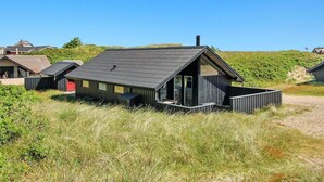 A modern, single-story building with a sloped roof, large windows, and a small deck area. - "Auli" - 200m from the sea by Interhome (Vejers Strand)