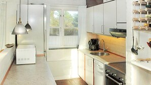 A compact kitchen with white cabinets, a built-in oven, a sink, and a coffee maker. - "Zuzan" - 500m from the sea by Interhome (Vejers Strand)