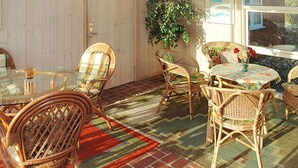 A dining area with wicker furniture, a glass table, and a patterned rug. - "Zuzan" - 500m from the sea by Interhome (Vejers Strand)