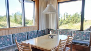 Un comedor con una mesa y sillas de madera, rodeado de bancos con motivos florales.