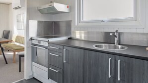 A modern kitchen with stainless steel appliances, a built-in oven, and a sink.