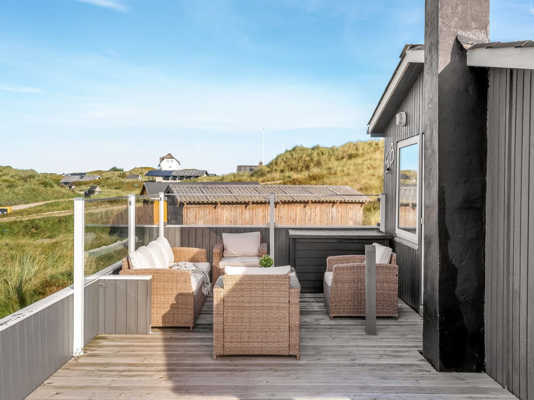 Eine Terrasse mit Korbmöbeln und Blick auf die Landschaft.