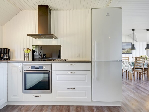 A modern kitchen with white cabinetry, a built-in oven, a stainless steel range, and a white refrigerator. - "Brunon" - 1.5km from the sea by Interhome (Vejers Strand)