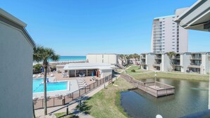 Ein Hotel mit Pool, einer kleinen Wasserattraktion und Blick auf den Strand.