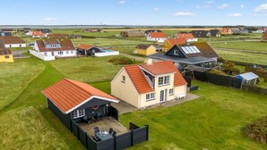 Una zona residenziale in campagna con case caratterizzate da tetti in tegole rosse e un mix di edifici a uno e due piani.