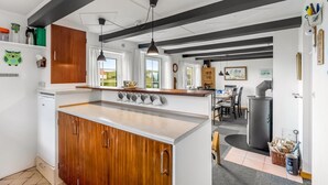 Una cucina moderna con mobili in legno, un'isola centrale e luci a sospensione.