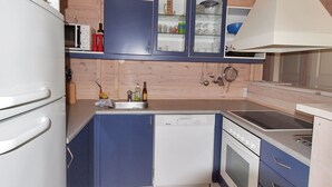 A compact kitchen with a dishwasher, stove, and cabinets.