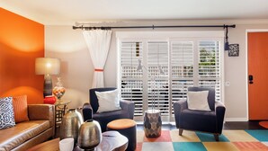 Un salon comprenant un canapé, deux fauteuils, une table basse et un tapis à motifs.
