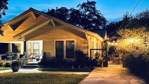 Une maison d’habitation avec un porche à l’avant, une allée et une pelouse bien entretenue.