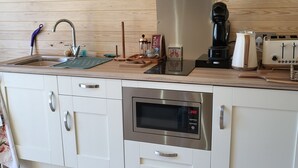 Een moderne keuken met een roestvrijstalen spoelbak, een koffiezetapparaat, een broodrooster en een magnetron.