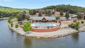 A lakeside resort with a swimming pool, guest cabins, and a covered outdoor area. - T Time Getaway - Overlooking Golf Views! (Branson West)