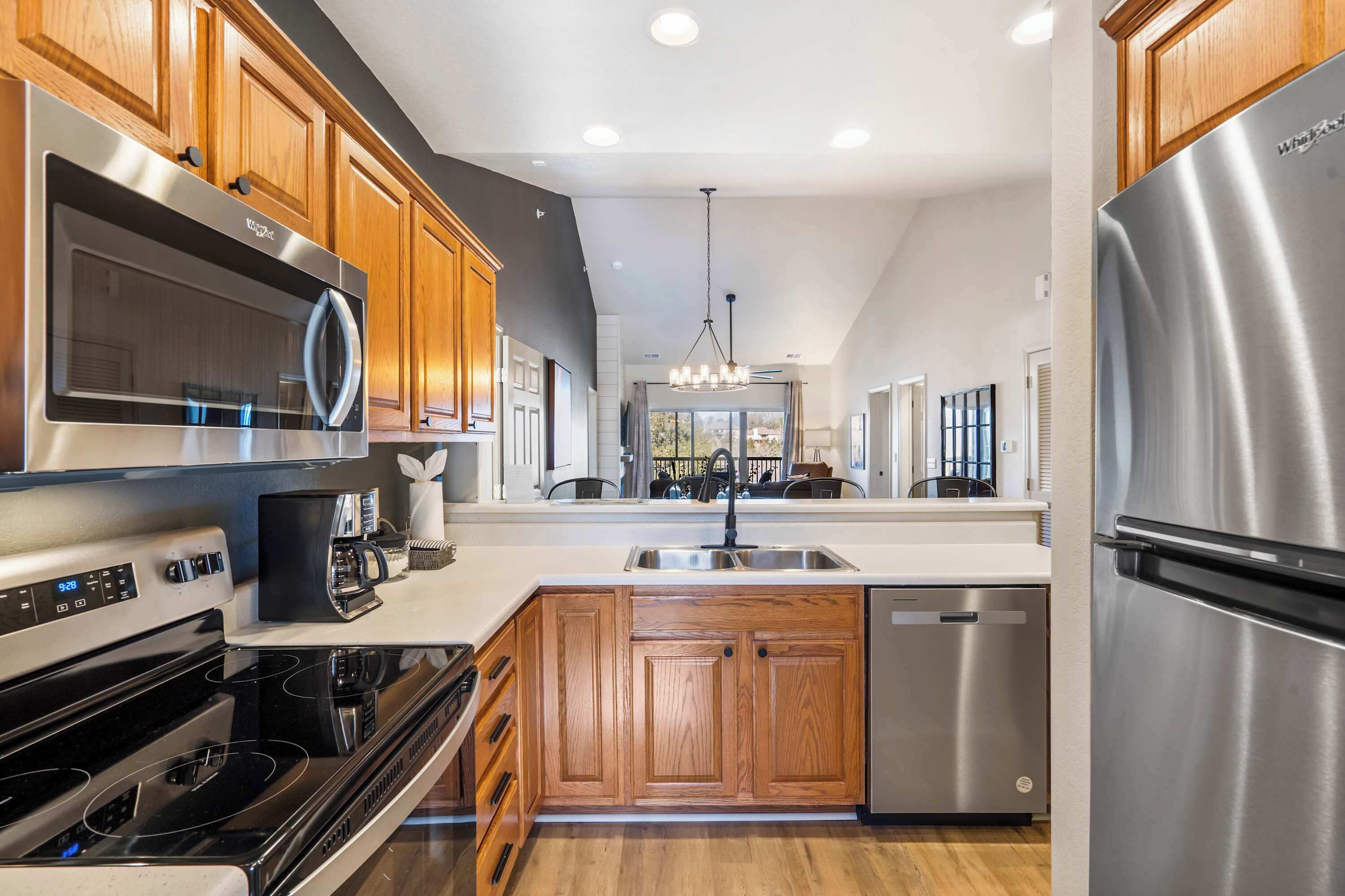A modern kitchen with stainless steel appliances, wooden cabinets, and a central island with a sink.