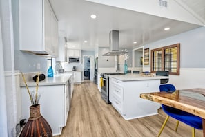 Enjoy cooking in this well-lit kitchen with a central island, white cabinetry, and microwave.