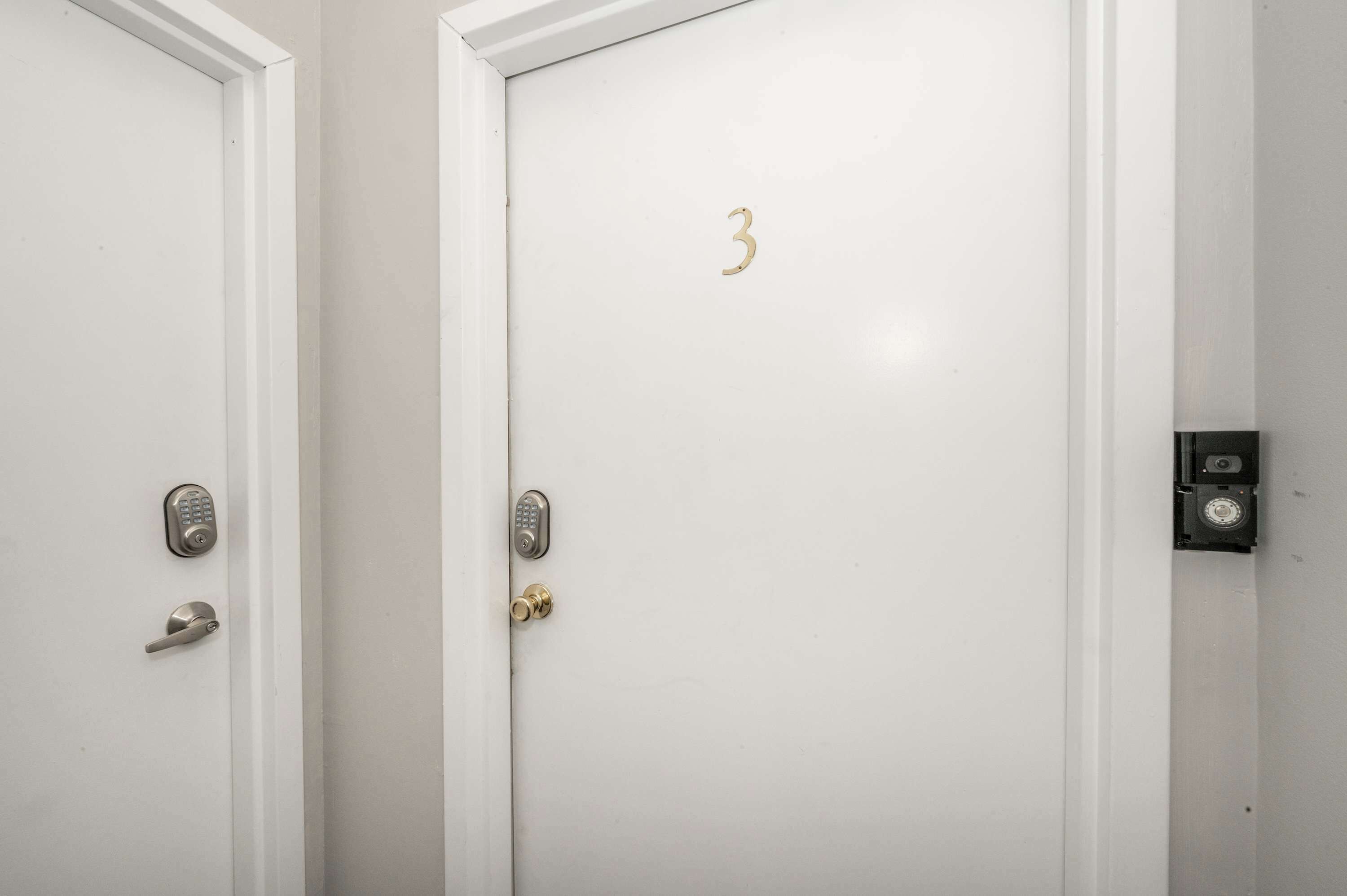 Two white doors with a numeric keypad and a keyhole, one marked with the number 3.