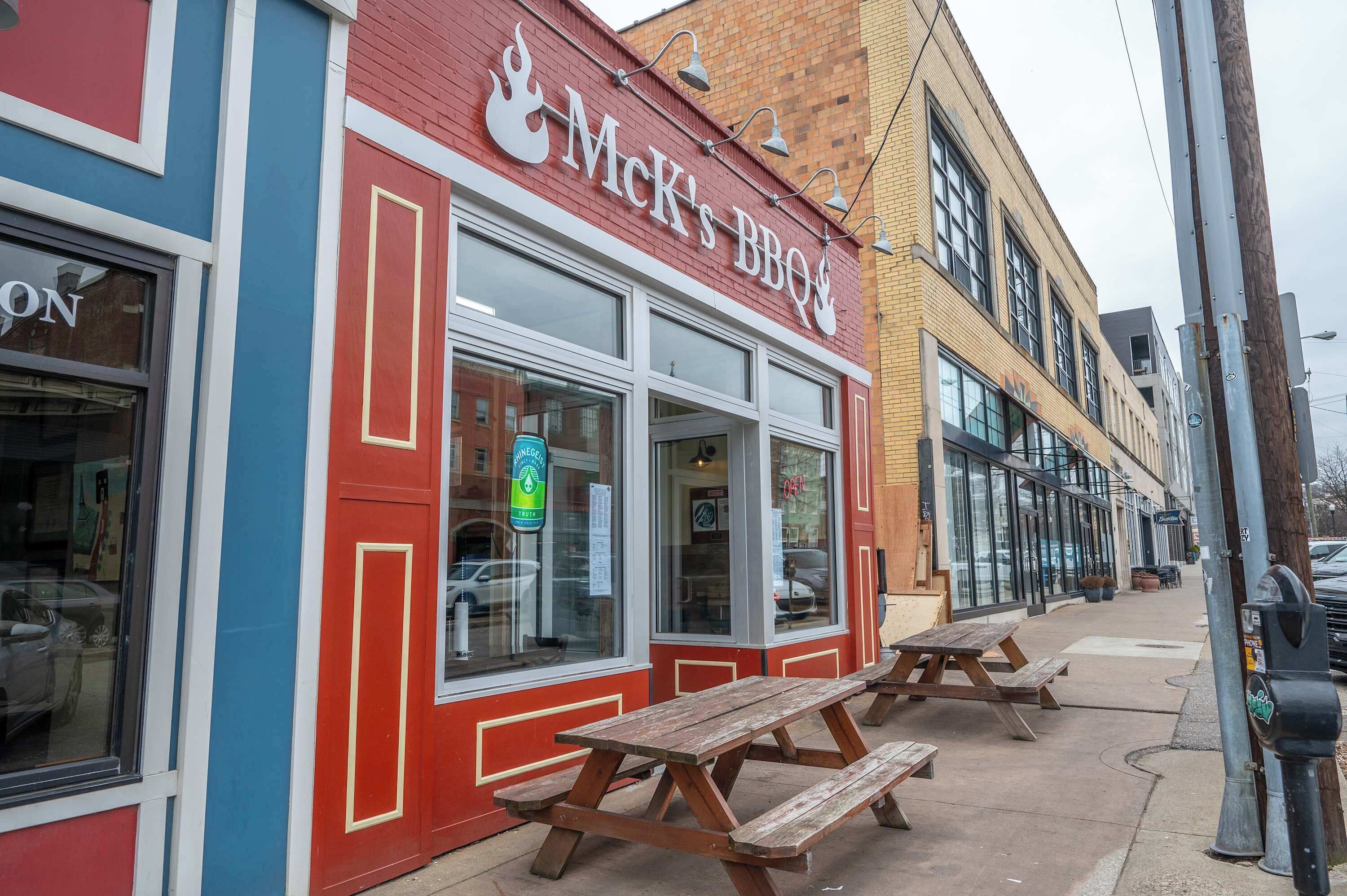 Une devanture de magasin rouge et bleue avec une enseigne indiquant « Mck's BBQ ».