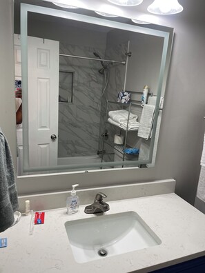 Een douche, handdoeken, zeep, toiletpapier