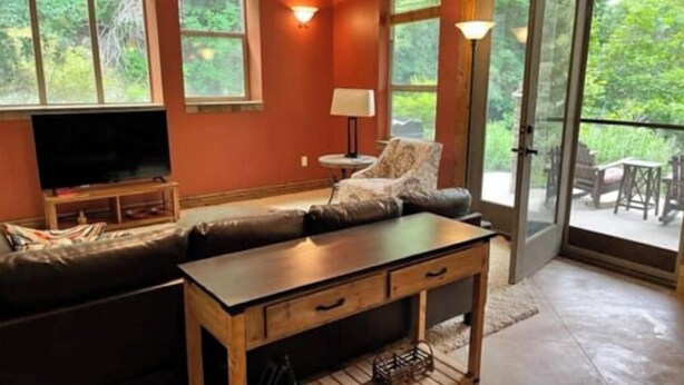 A cozy living room with a sectional sofa, a wooden coffee table, and a TV on a stand. - Mountain Apartment, Minutes to Resorts & Services (Ogden)