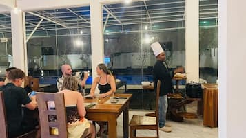 Ein Restaurant mit Holztischen und -stühlen, großen Fenstern und einem modernen Interieur.