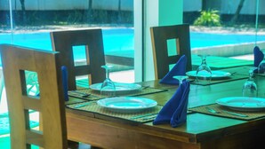 Une table à manger dressée pour quatre personnes, avec des chaises, des assiettes, des couverts et des serviettes.