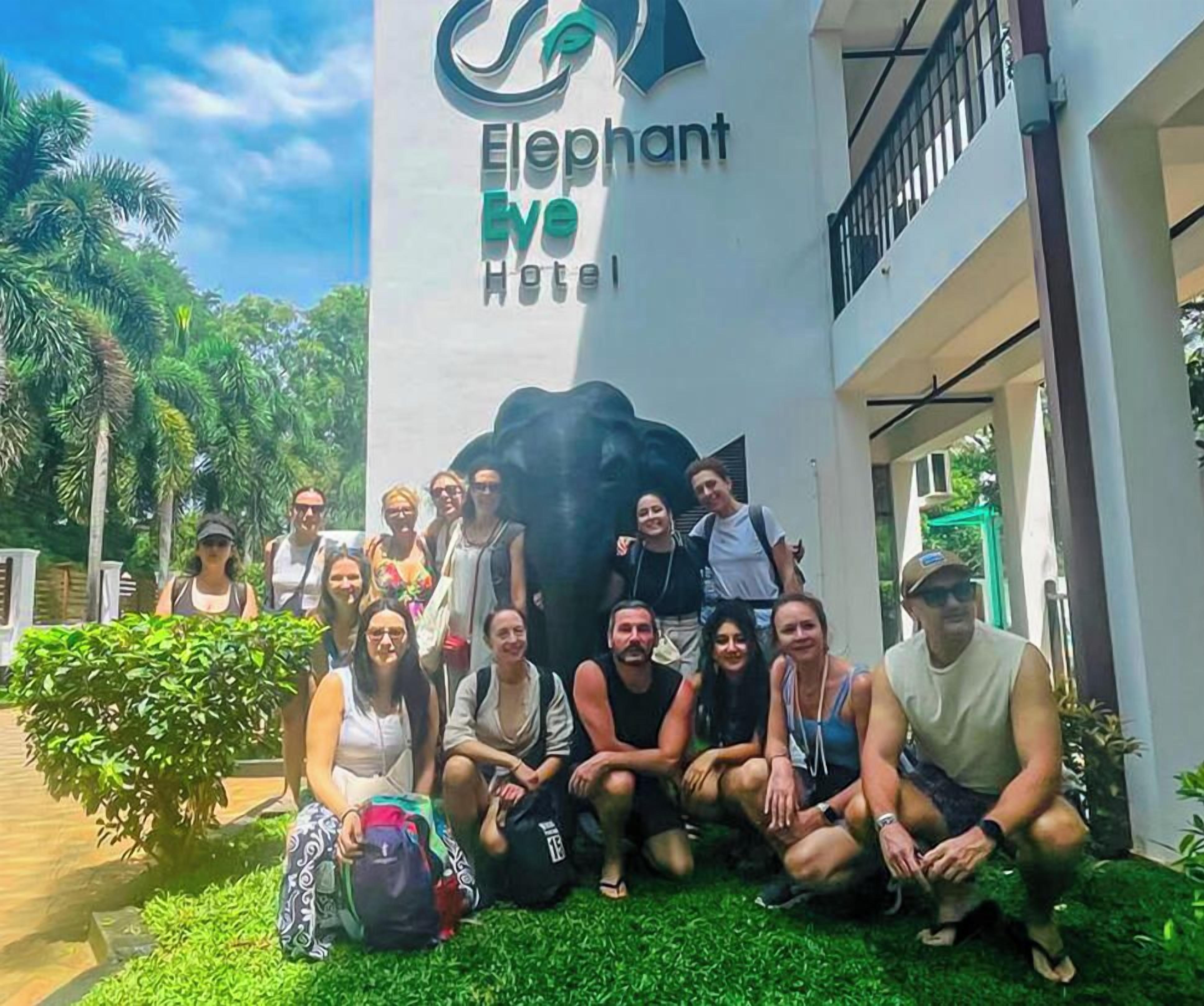 A group of people posing in front of the Elephant We Hotel.