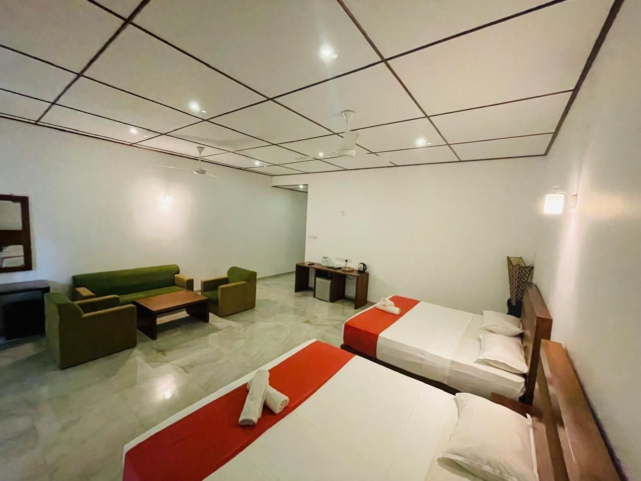 Une chambre d’hôtel avec un lit, un canapé, un bureau et une chaise.