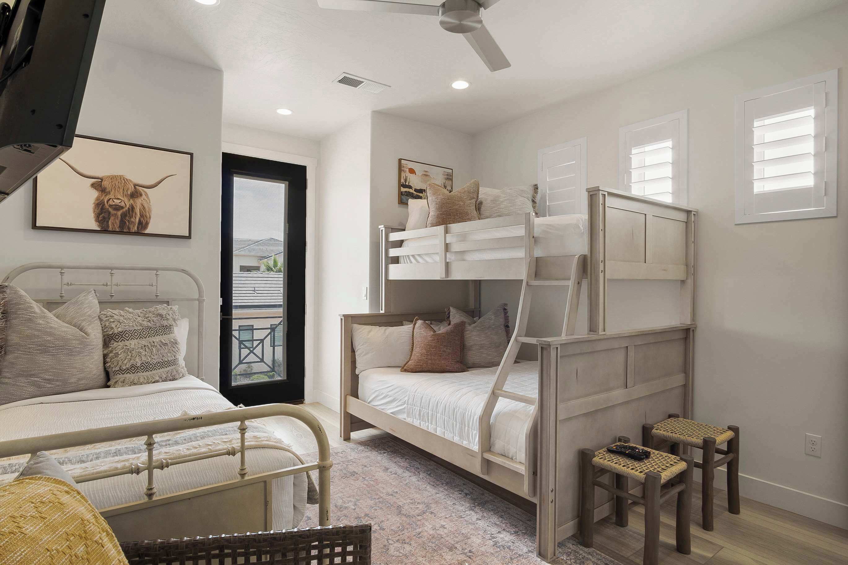 A bedroom with bunk beds, a ceiling fan, and a window with blinds.