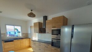 A modern kitchen with wooden cabinets, a stainless steel refrigerator, and a built-in oven. - Villa with 4 bedrooms and pool (FRESPECH)