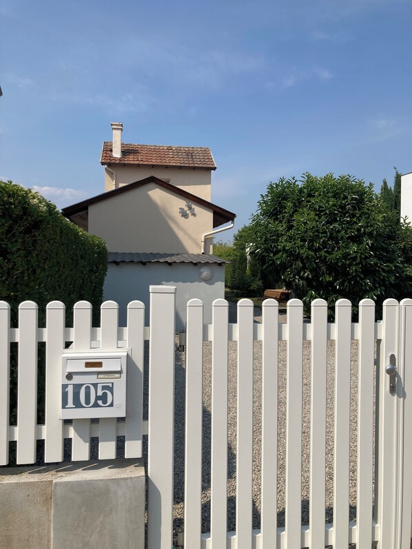 A white picket fence with a mailbox labeled '105'.