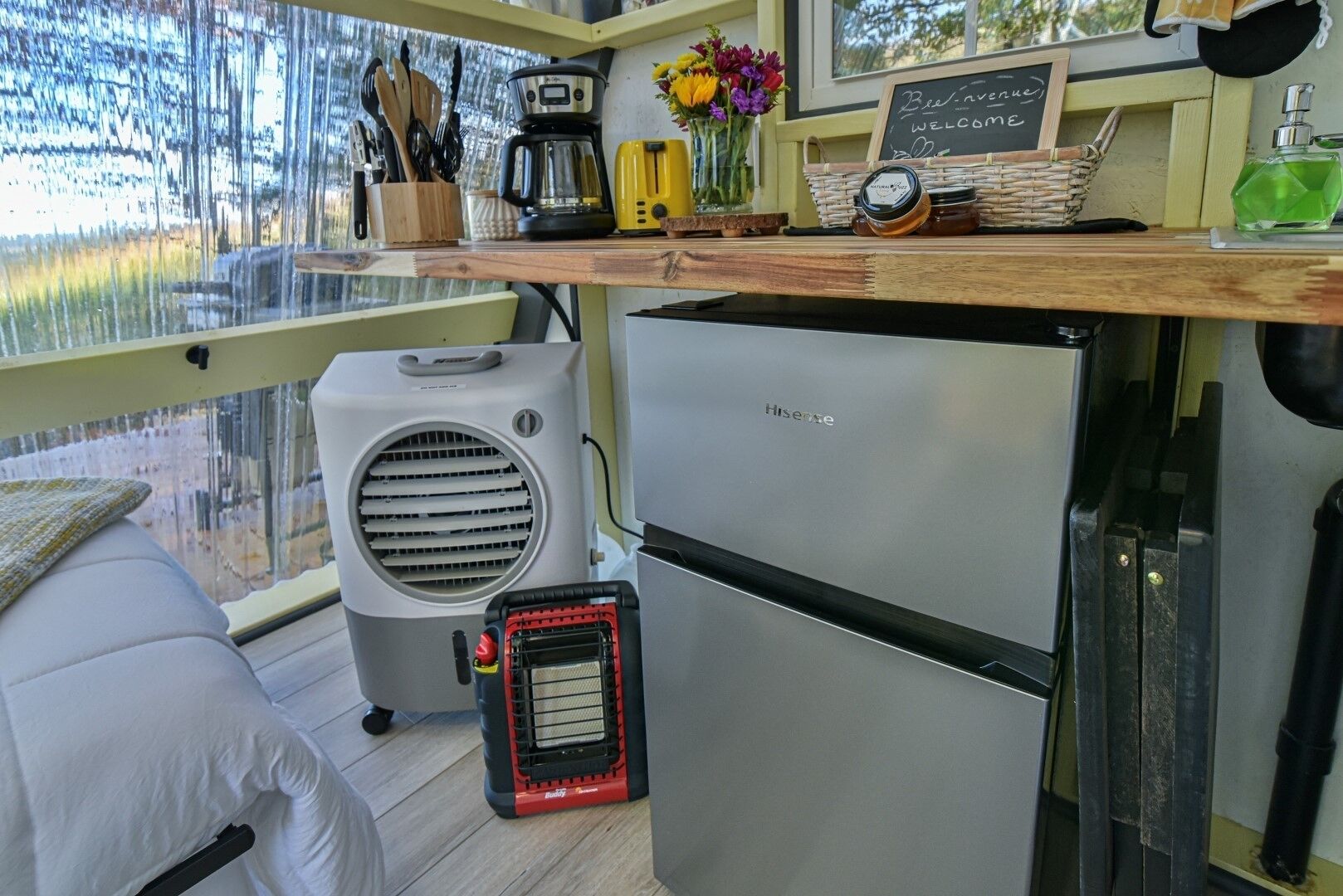 Une cuisine compacte équipée d’une machine à café, d’un grille-pain et d’un tableau noir.