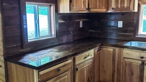A kitchen with wooden cabinets, a window, and a countertop.