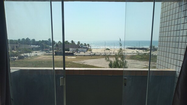 Ein Balkon mit Blick auf Strand und Meer.