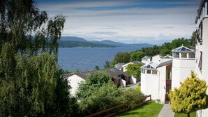 Un quartier résidentiel au bord du lac, avec des maisons, une vue sur le lac et des montagnes à l’horizon.