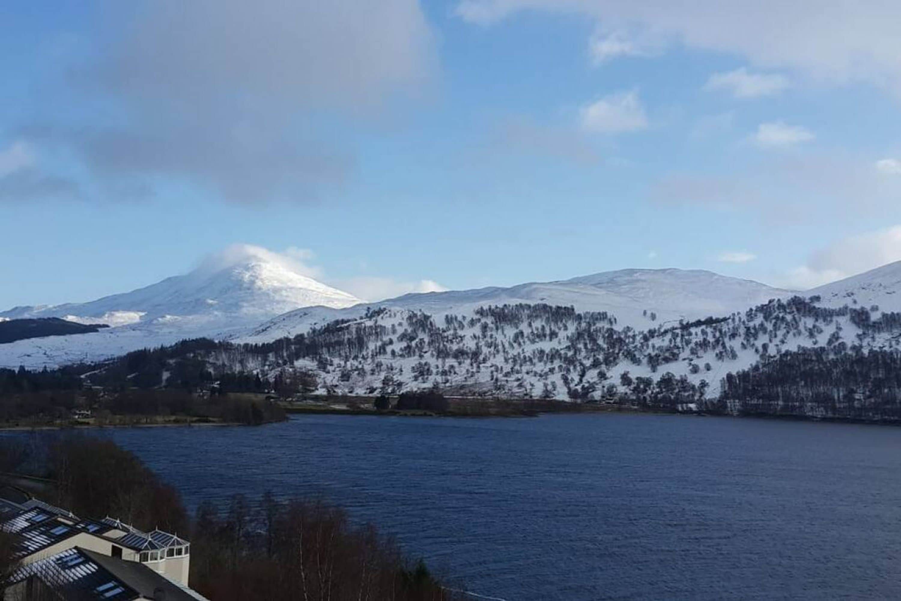 A lake with snow-covered mountains in the background.