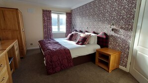 A bedroom with a bed, wooden wardrobe, and a small wooden table. - Highland Lodge 36 Loch Rannoch Highland Club (Pitlochry)
