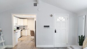 A modern living room with a sofa, a coffee table, and a kitchen in the background. - 1BR House in Glendale With Private Fenced Yard p55 (Glendale)