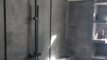 Chuveiro, toalhas de banho, sabonete, shampoo