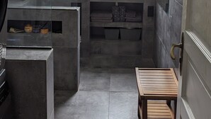 Ein modernes Badezimmer mit großem Fenster, integriertem Waschtisch und einer kleinen Holzbank.