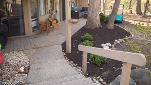 A patio area with outdoor seating, a wooden bench, and a tree. - Windmill Cottage at Abbey Springs Near Lake & Shops! (Fontana)