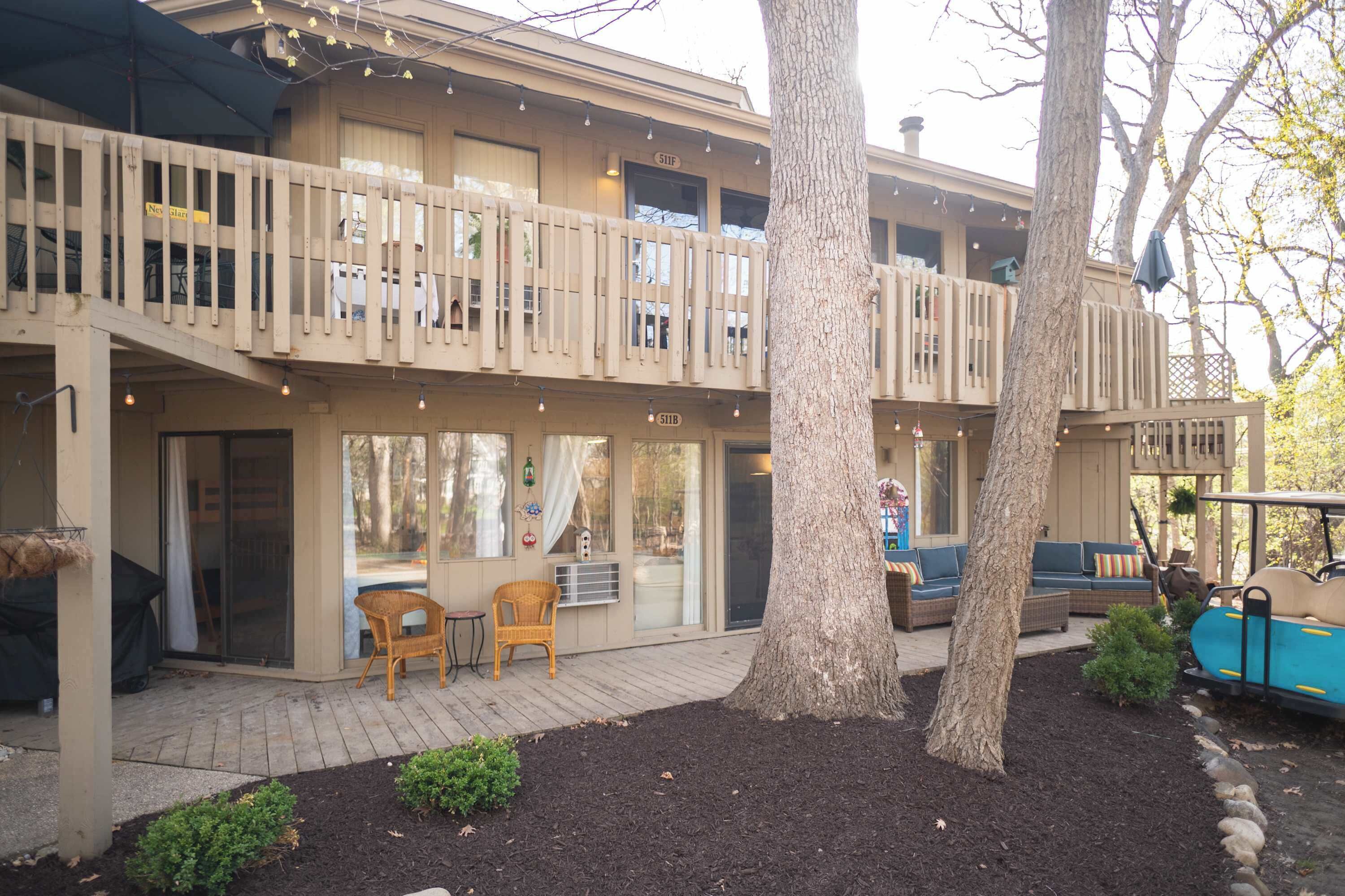 A two-story building with a balcony, outdoor seating, and a golf cart.