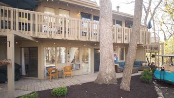 A two-story building with a balcony, outdoor seating, and a golf cart.