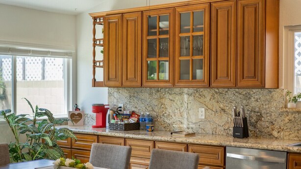 Cucina con mobili in legno, piano di lavoro in granito e lavastoviglie in acciaio inossidabile.