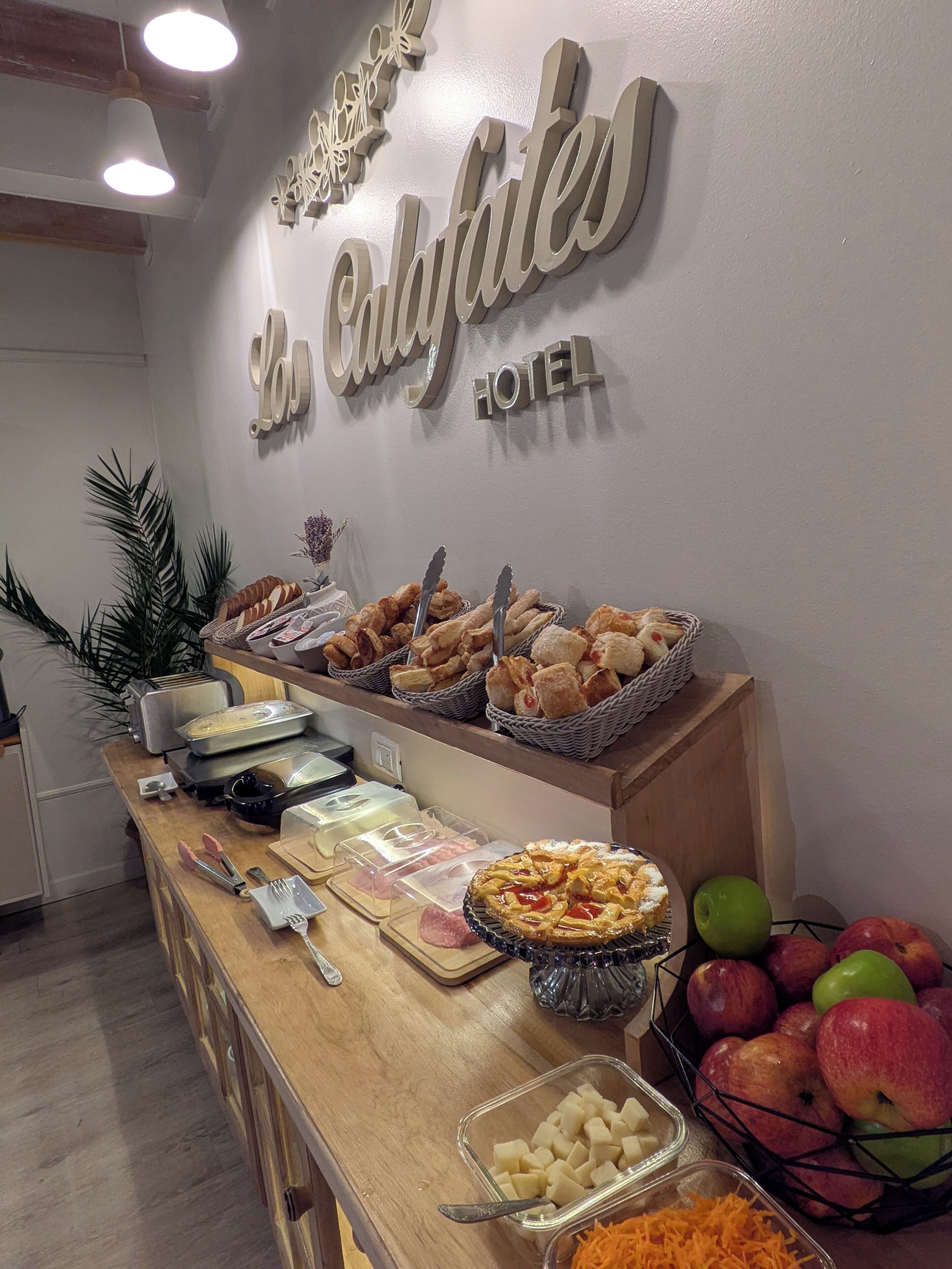 Montaje tipo buffet con diversos alimentos y un cartel que dice 'Hotel Calafates'.