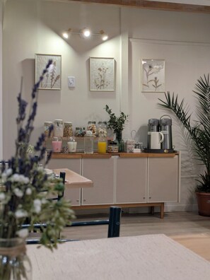 A kitchen with a wooden countertop, jars, a coffee maker, and a potted plant. - Los Calafates Hotel (Ushuaia)