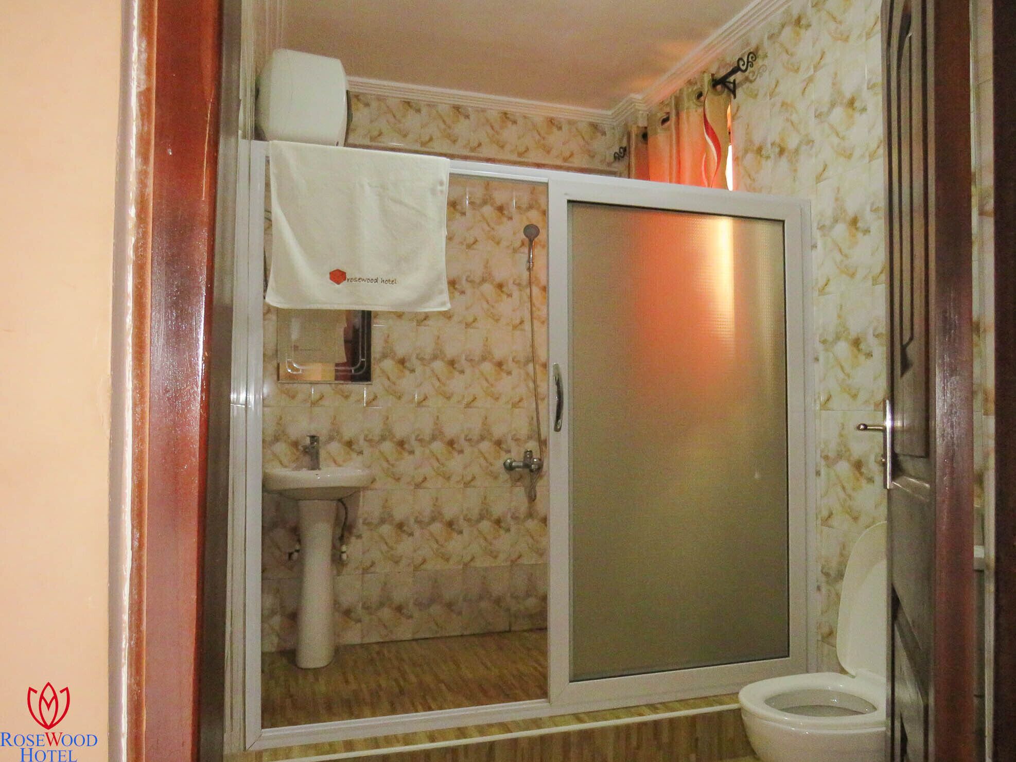 A bathroom with a shower, toilet, and sink.